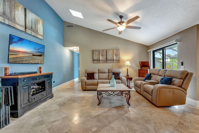 living room featuring lofted ceiling with skylight, visible vents, baseboards, and a ceiling fan