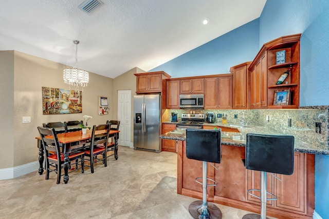 kitchen featuring stone countertops, stainless steel appliances, visible vents, vaulted ceiling, and brown cabinets