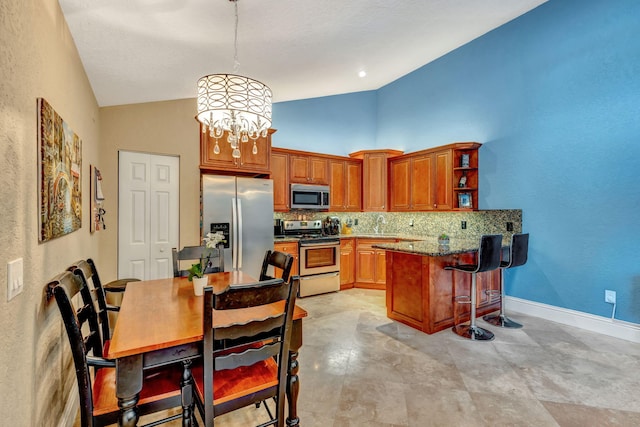 kitchen with stainless steel appliances, a breakfast bar, a peninsula, decorative backsplash, and an inviting chandelier