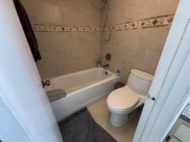 full bathroom with toilet, tile patterned flooring,  shower combination, and tile walls