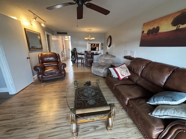 living area featuring rail lighting, ceiling fan, visible vents, and wood finished floors