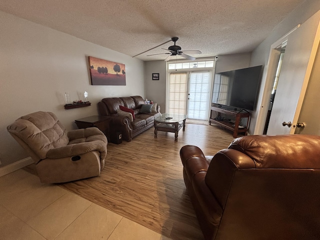 living area featuring ceiling fan, a textured ceiling, and light wood finished floors