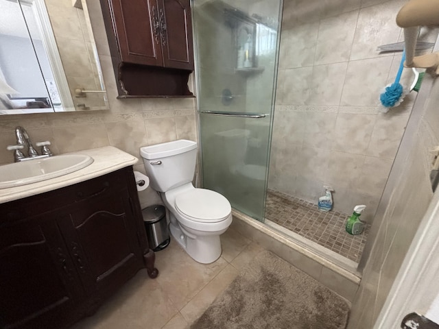 bathroom with a stall shower, tile patterned flooring, tile walls, and vanity