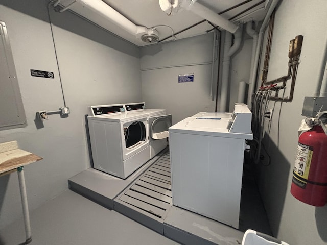 shared laundry area with electric panel and washer and dryer