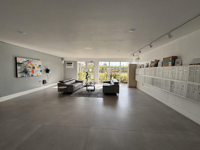 interior space featuring a wall mounted air conditioner, rail lighting, mail area, and baseboards