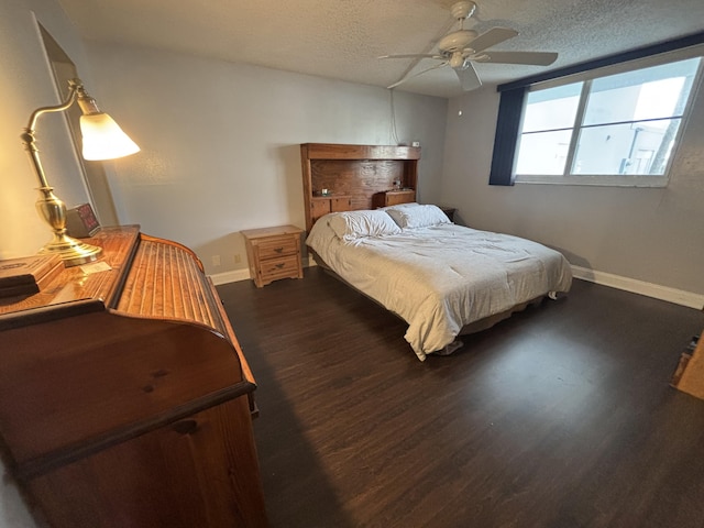 bedroom with dark wood-style floors, a textured ceiling, baseboards, and a ceiling fan