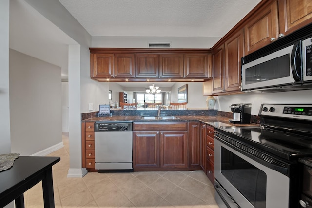 kitchen featuring visible vents, a sink, appliances with stainless steel finishes, an inviting chandelier, and light tile patterned floors