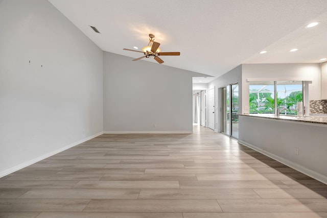 spare room featuring lofted ceiling, recessed lighting, ceiling fan, light wood-type flooring, and baseboards