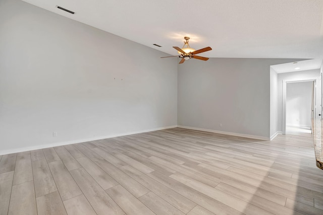 spare room with light wood-type flooring, visible vents, ceiling fan, and baseboards