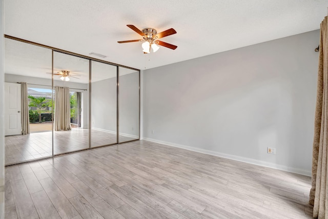 unfurnished bedroom with visible vents, light wood-style flooring, baseboards, and a textured ceiling