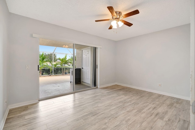 unfurnished room featuring a textured ceiling, light wood-style flooring, and baseboards