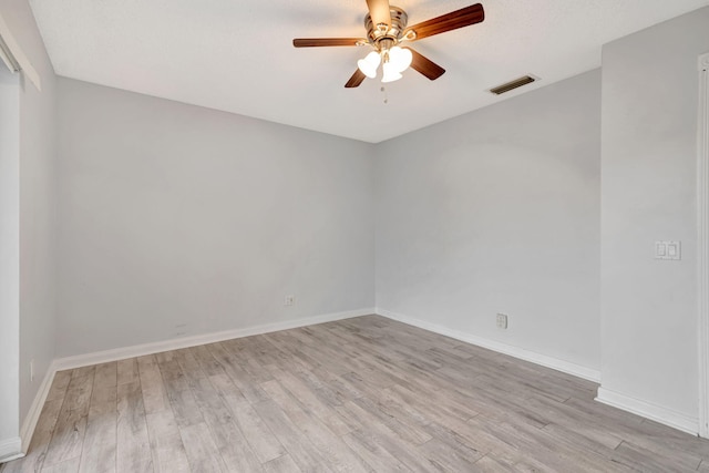 empty room featuring baseboards, visible vents, ceiling fan, and wood finished floors