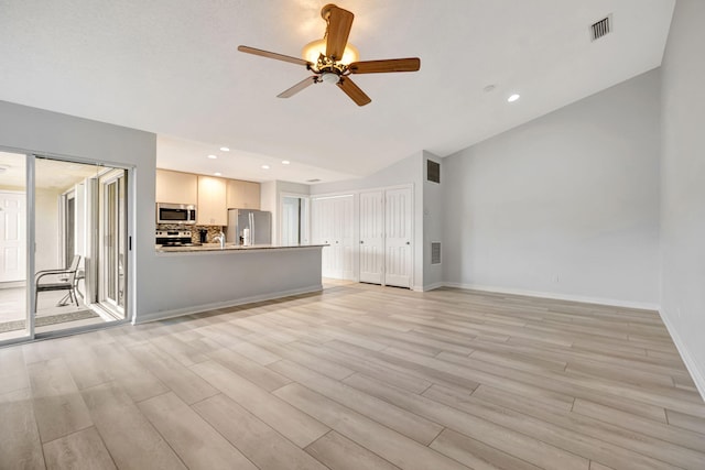 unfurnished living room featuring ceiling fan, visible vents, baseboards, vaulted ceiling, and light wood-type flooring