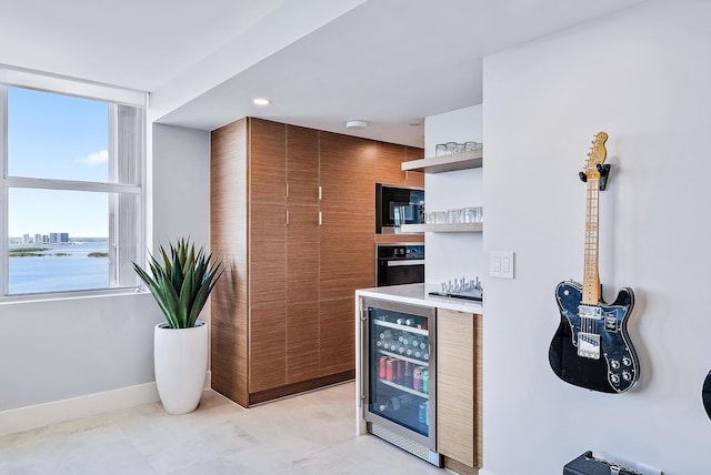 kitchen featuring open shelves, light countertops, beverage cooler, oven, and baseboards