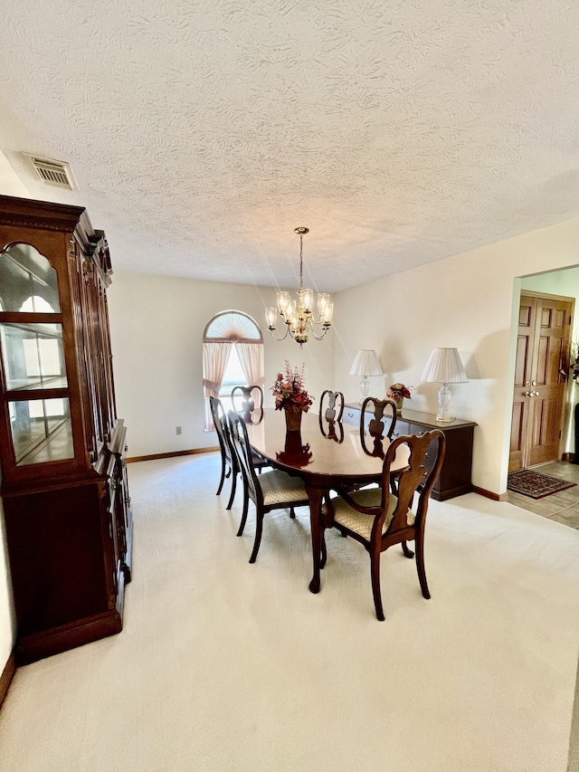 dining area featuring baseboards, an inviting chandelier, visible vents, and light colored carpet