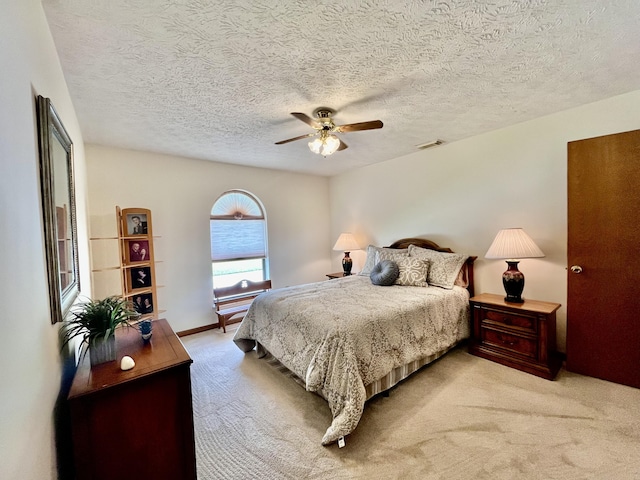 bedroom with light carpet, ceiling fan, a textured ceiling, and visible vents