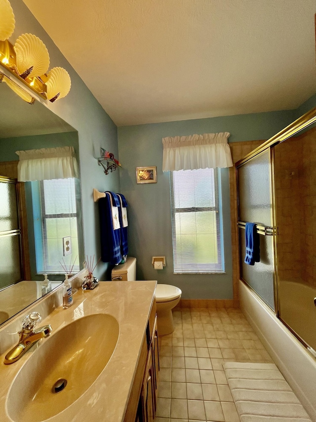 full bath featuring toilet, enclosed tub / shower combo, vanity, tile patterned flooring, and baseboards