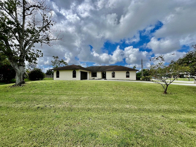 view of front of property featuring a front lawn, fence, and stucco siding