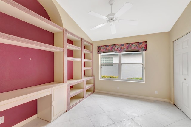 unfurnished bedroom featuring light tile patterned floors, baseboards, lofted ceiling, ceiling fan, and a closet