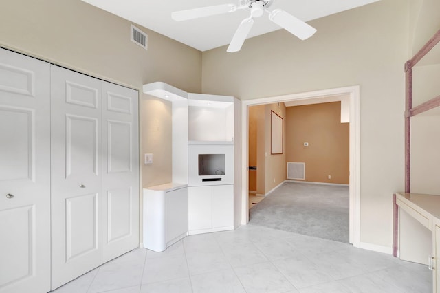 unfurnished bedroom with light colored carpet, a closet, visible vents, and ceiling fan