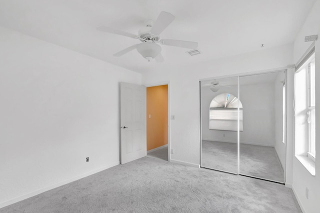 unfurnished bedroom with carpet floors, visible vents, a ceiling fan, baseboards, and a closet