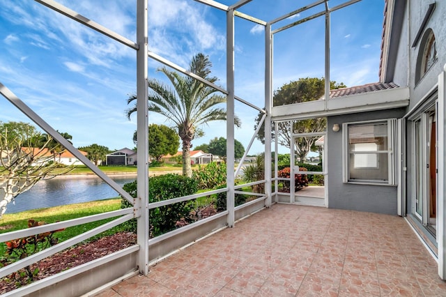 unfurnished sunroom featuring a water view