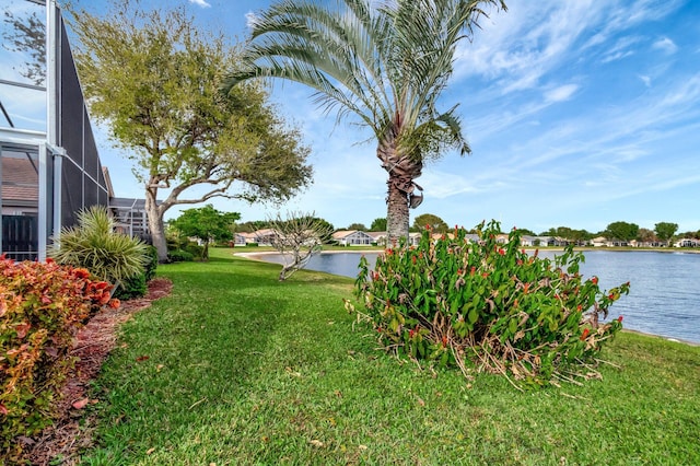 view of yard featuring a water view and glass enclosure