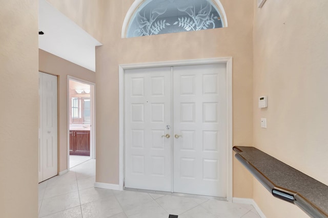 foyer featuring light tile patterned floors and baseboards