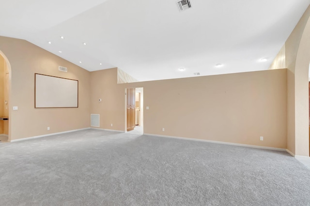 spare room featuring vaulted ceiling, visible vents, and arched walkways