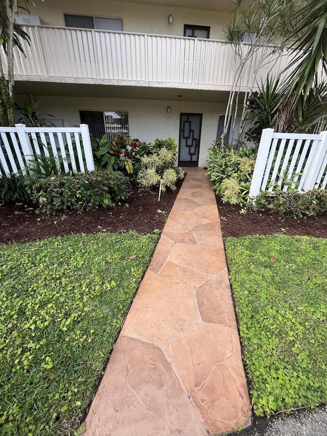 entrance to property with a balcony and stucco siding