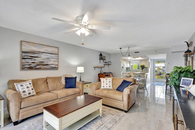 living room with marble finish floor, visible vents, ceiling fan, and a textured ceiling