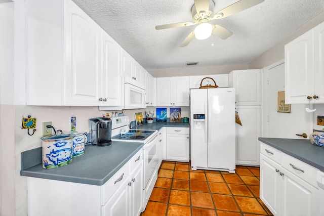 kitchen featuring white appliances, white cabinetry, dark countertops, visible vents, and ceiling fan