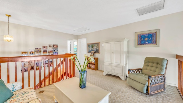 living area with light carpet, visible vents, a chandelier, and an upstairs landing