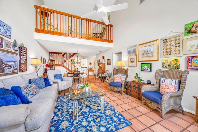 tiled living room featuring ceiling fan with notable chandelier and a high ceiling