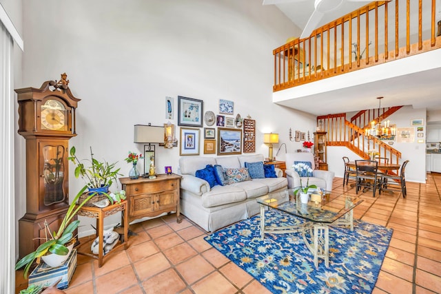 tiled living area with a towering ceiling, an inviting chandelier, and stairs