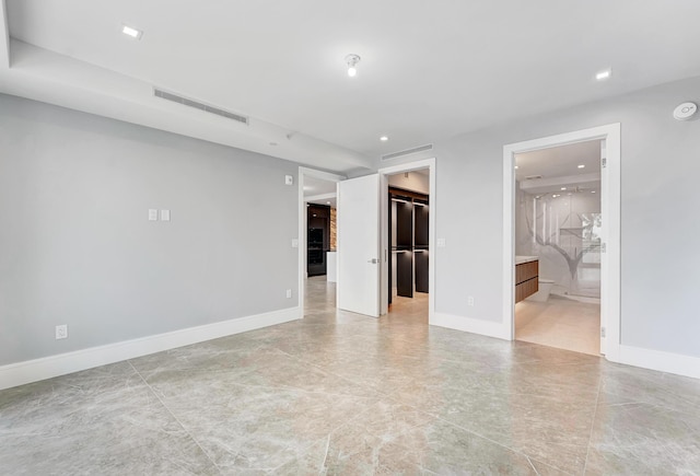 spare room featuring baseboards, visible vents, and recessed lighting