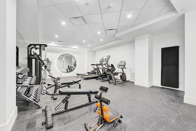 workout area featuring a paneled ceiling, baseboards, and recessed lighting