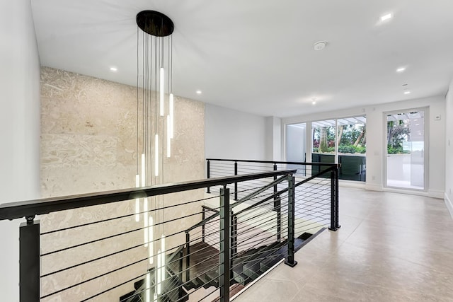 hallway with baseboards, an upstairs landing, and recessed lighting