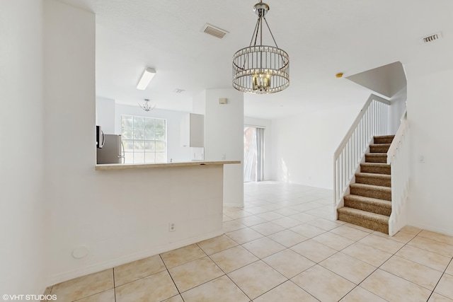 interior space featuring stairs, visible vents, a notable chandelier, and light tile patterned flooring