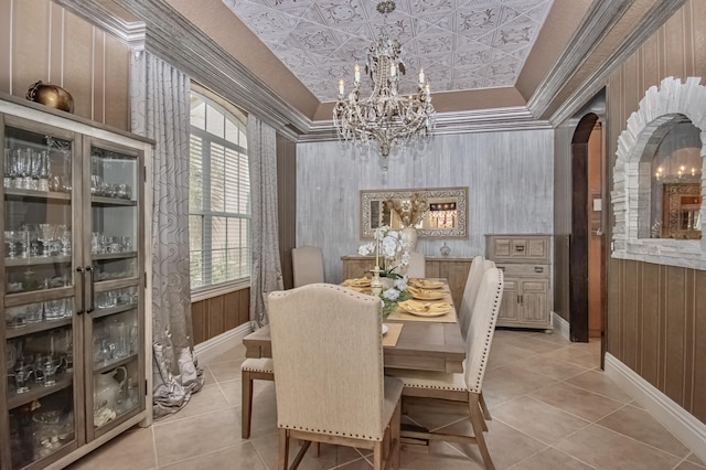 dining area featuring an ornate ceiling, baseboards, arched walkways, and an inviting chandelier