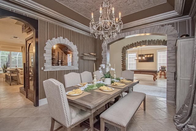 dining area featuring arched walkways, an inviting chandelier, crown molding, and an ornate ceiling