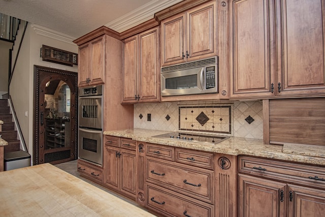 kitchen featuring stainless steel appliances, brown cabinetry, backsplash, and crown molding