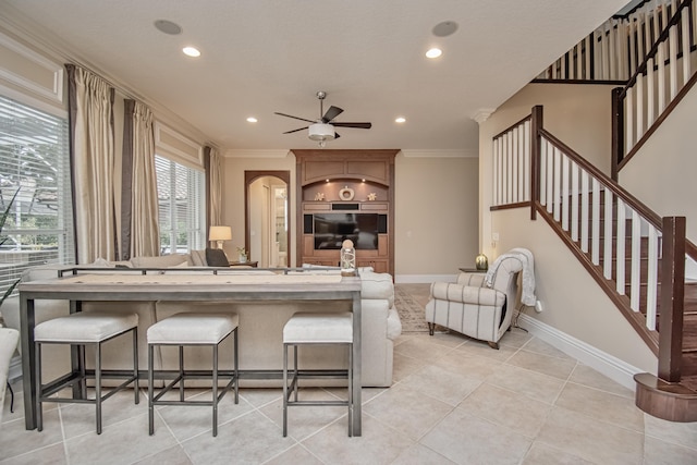 kitchen with crown molding, light tile patterned floors, baseboards, and a ceiling fan