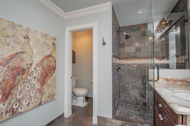 bathroom with crown molding, vanity, toilet, a stall shower, and baseboards