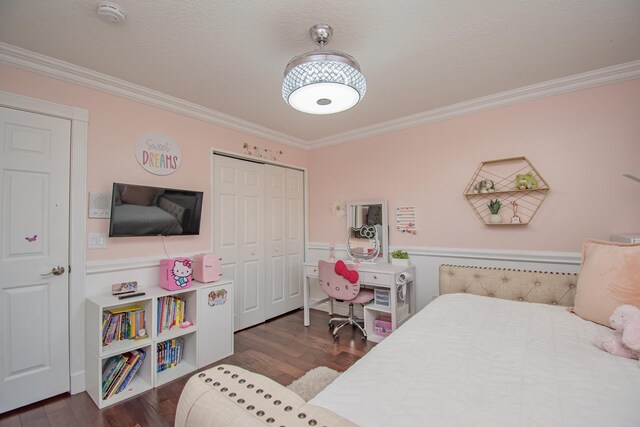 bedroom featuring ornamental molding, a closet, and dark wood finished floors
