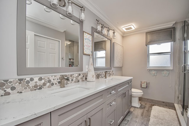 bathroom with toilet, tasteful backsplash, a sink, and ornamental molding