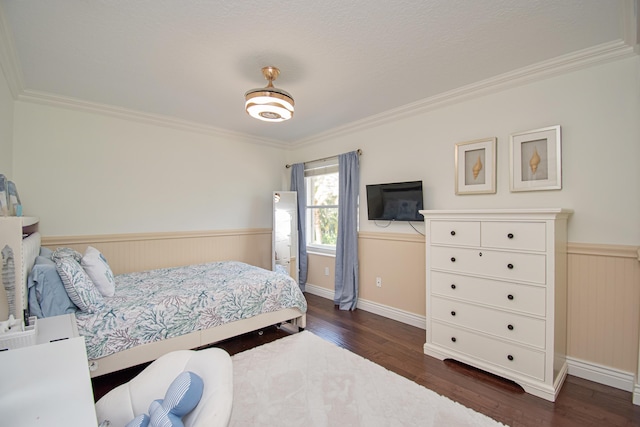 bedroom with wainscoting, ornamental molding, and dark wood finished floors