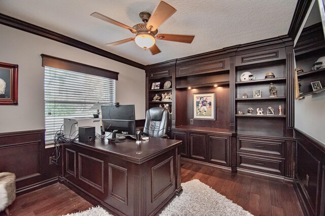 office with ornamental molding, a ceiling fan, a textured ceiling, wainscoting, and dark wood-type flooring