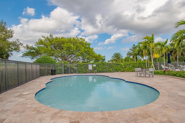 pool with a patio area and fence