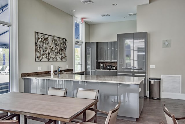 kitchen with a healthy amount of sunlight, a sink, dark wood-style floors, and visible vents